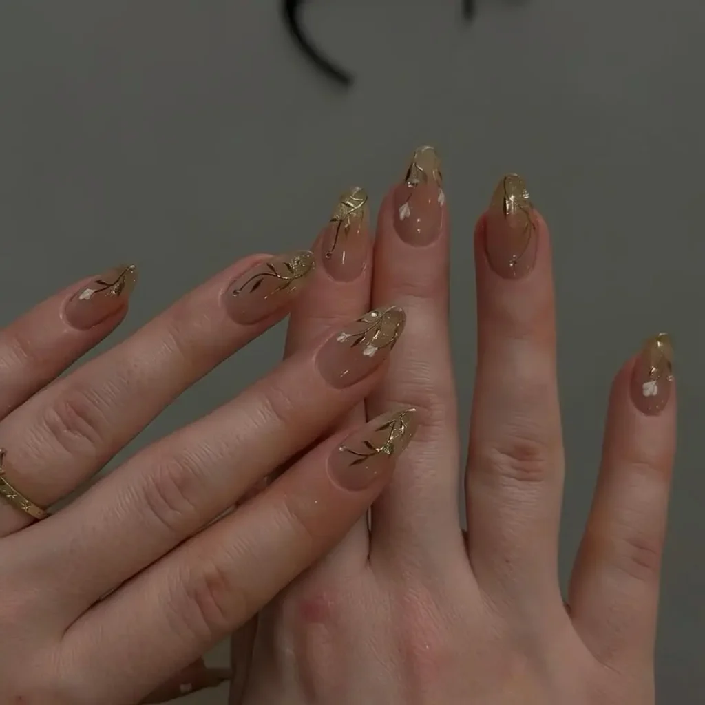 Soft Nude Nails with Gold Leaf Tips and Botanical Details 