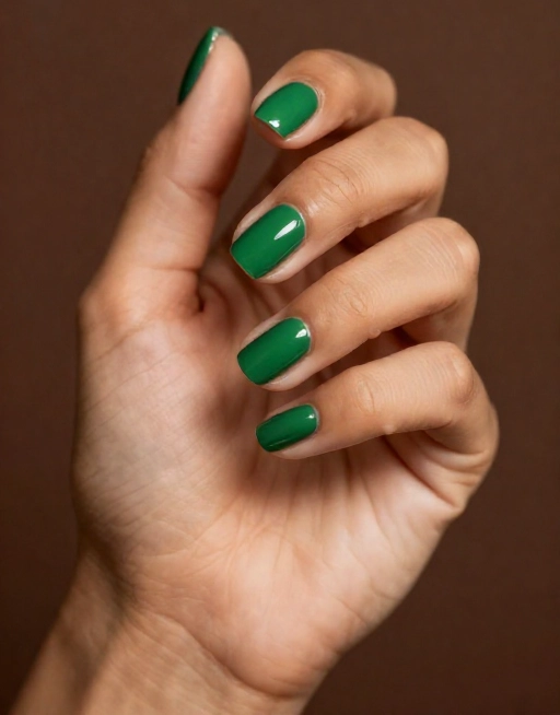 emerald green nail polish on deep skin hand