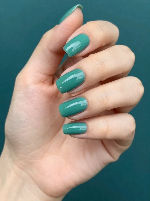glossy chip free teal nail polish on a well manicured hand