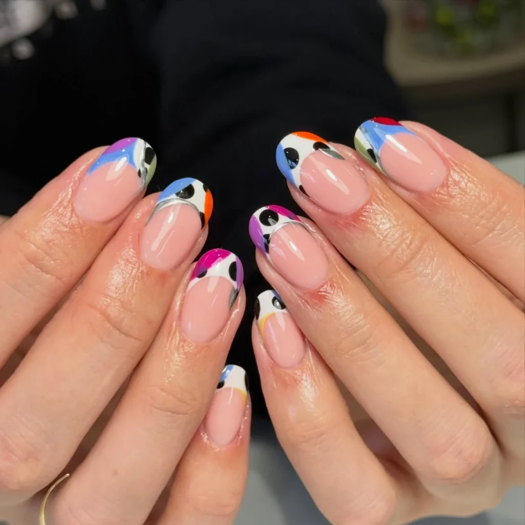 Cool girl nail designs with bare nude base and abstract multicolor French tips dotted with black cow print spots