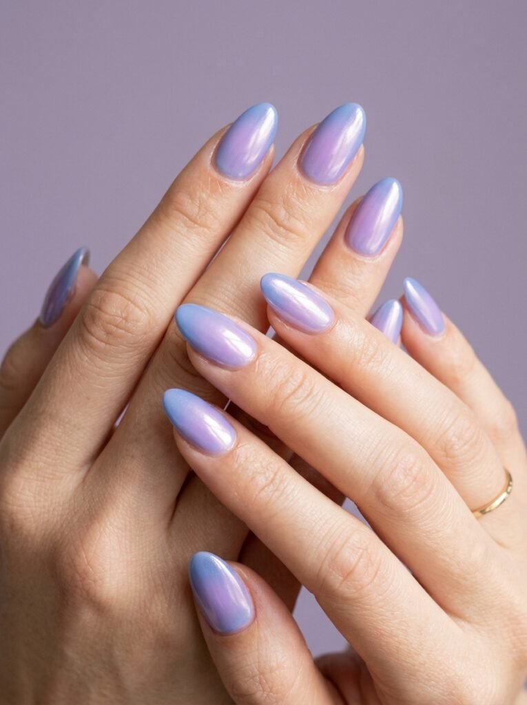 Cool girl nail designs with a blended aura glow of cool blue and lilac over a sheer base on almond nails