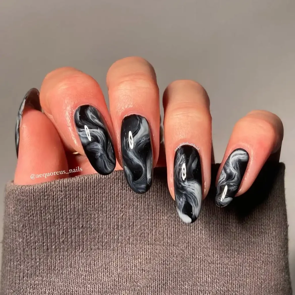 Cool girl nail designs in smoky black marble with grey and white swirls on long almond nails