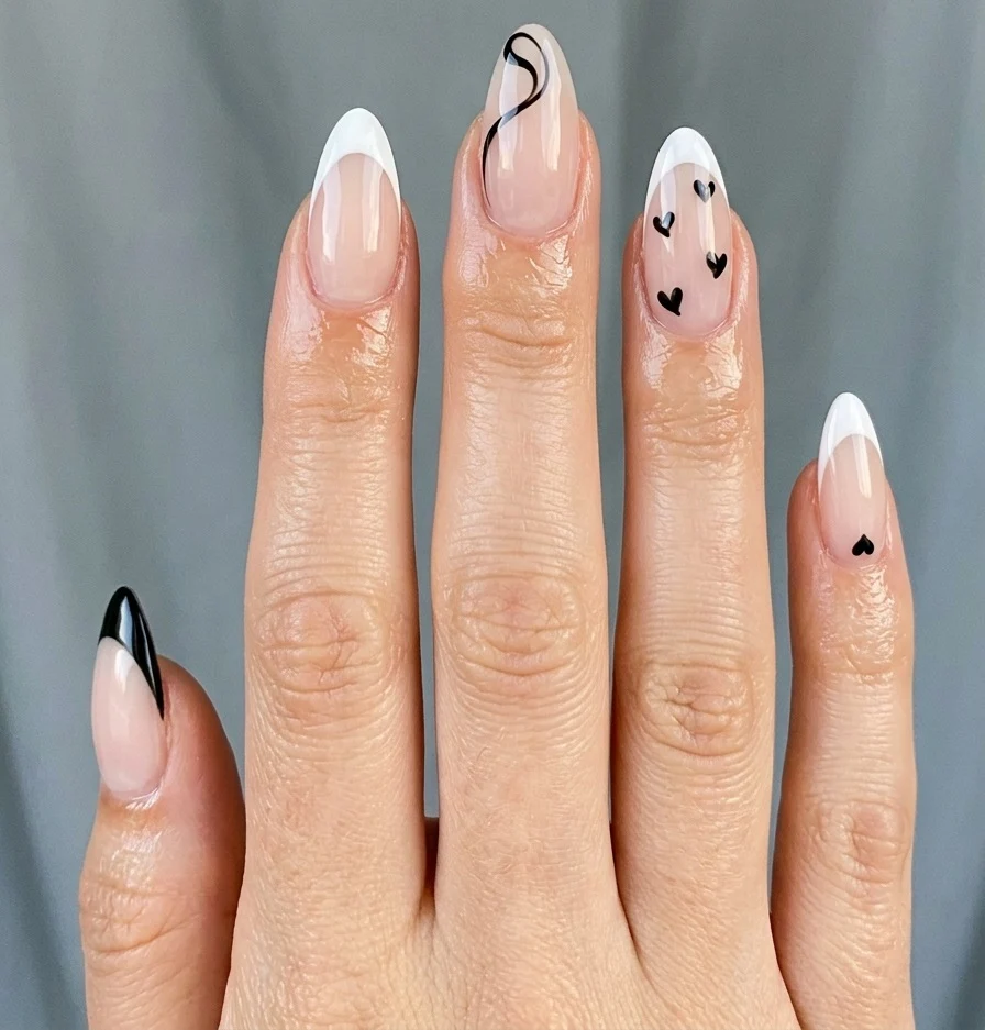 Cool girl nail designs with a sheer milky white base and thin black line French tips on short almond nails
