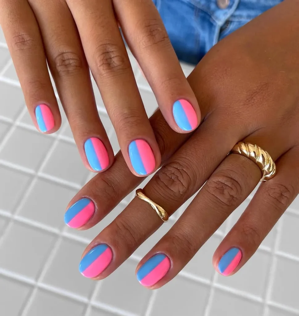 Cool girl nail designs with a two tone color block split of hot pink and sky blue on short round nails