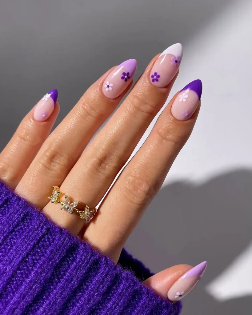 Cool girl nail designs with lilac and grape purple French tips and tiny daisies on sheer almond nails
