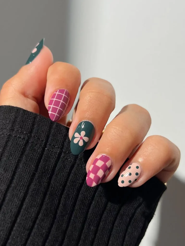 Retro cool girl nail designs in berry pink and forest green with grid, daisy, checkerboard, and polka dot patterns on almond nails