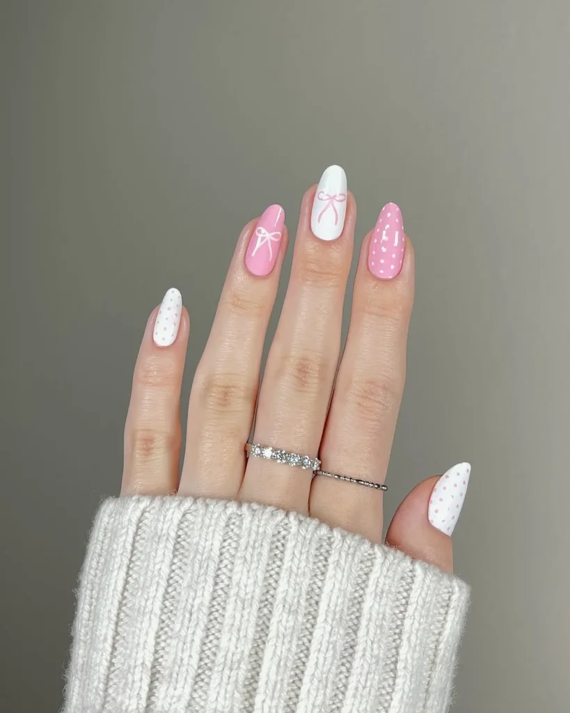 Coquette Hello Kitty inspired nails with hand-drawn pink and white bows and polka dots on short almond nails, no character face