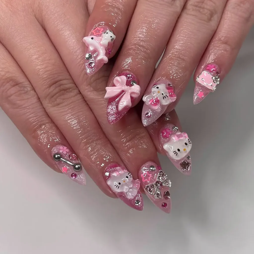 Pink maximalist Hello Kitty stiletto nails with a 3D Kitty on a dolphin, big bows, rhinestones, stars, and glitter