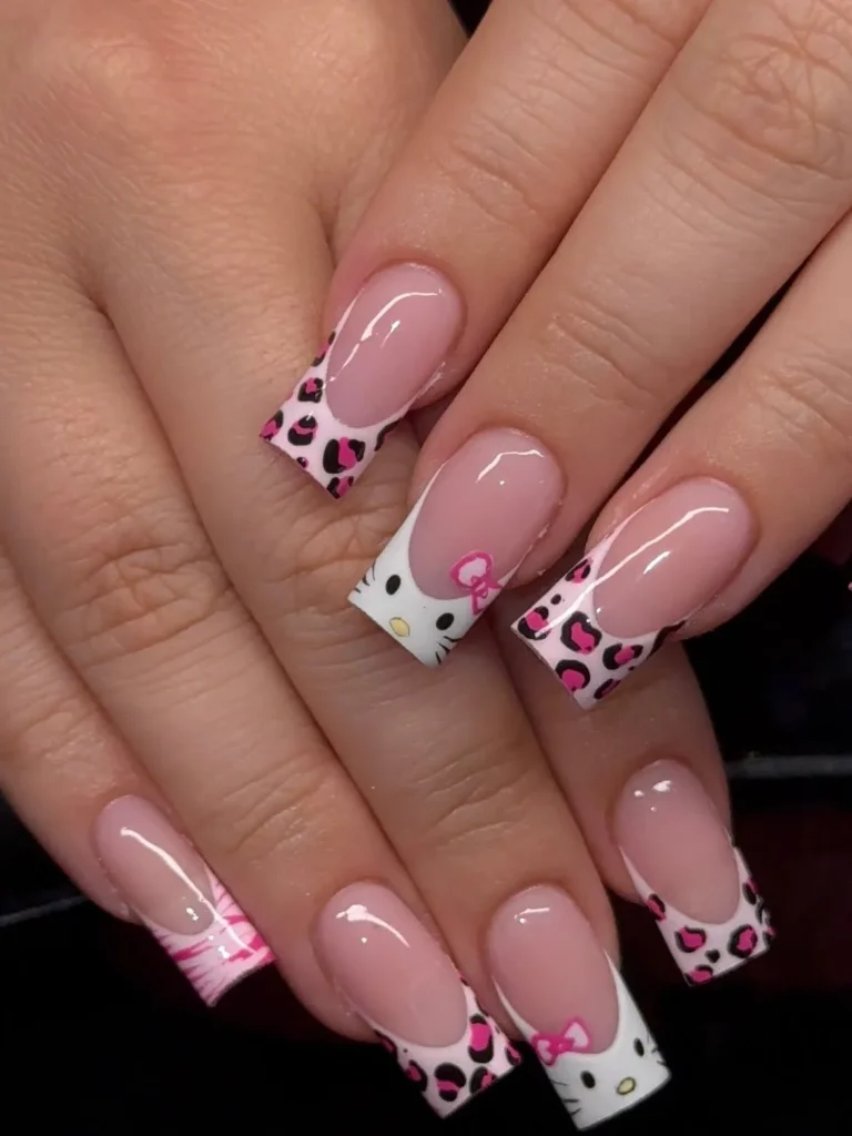 Pink Hello Kitty nails with pink and black leopard print French tips, a Hello Kitty face accent, and pink bows on long square nails