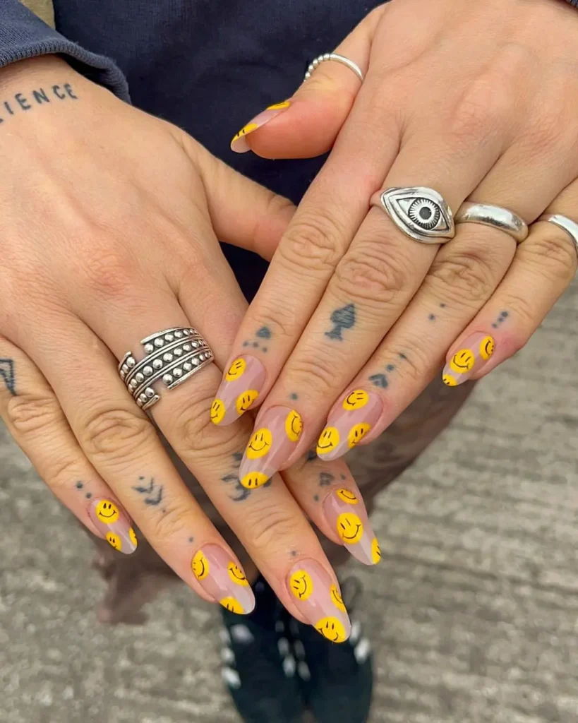 Summer smiley face nails with all-over classic yellow smiley faces on long nude almond nails