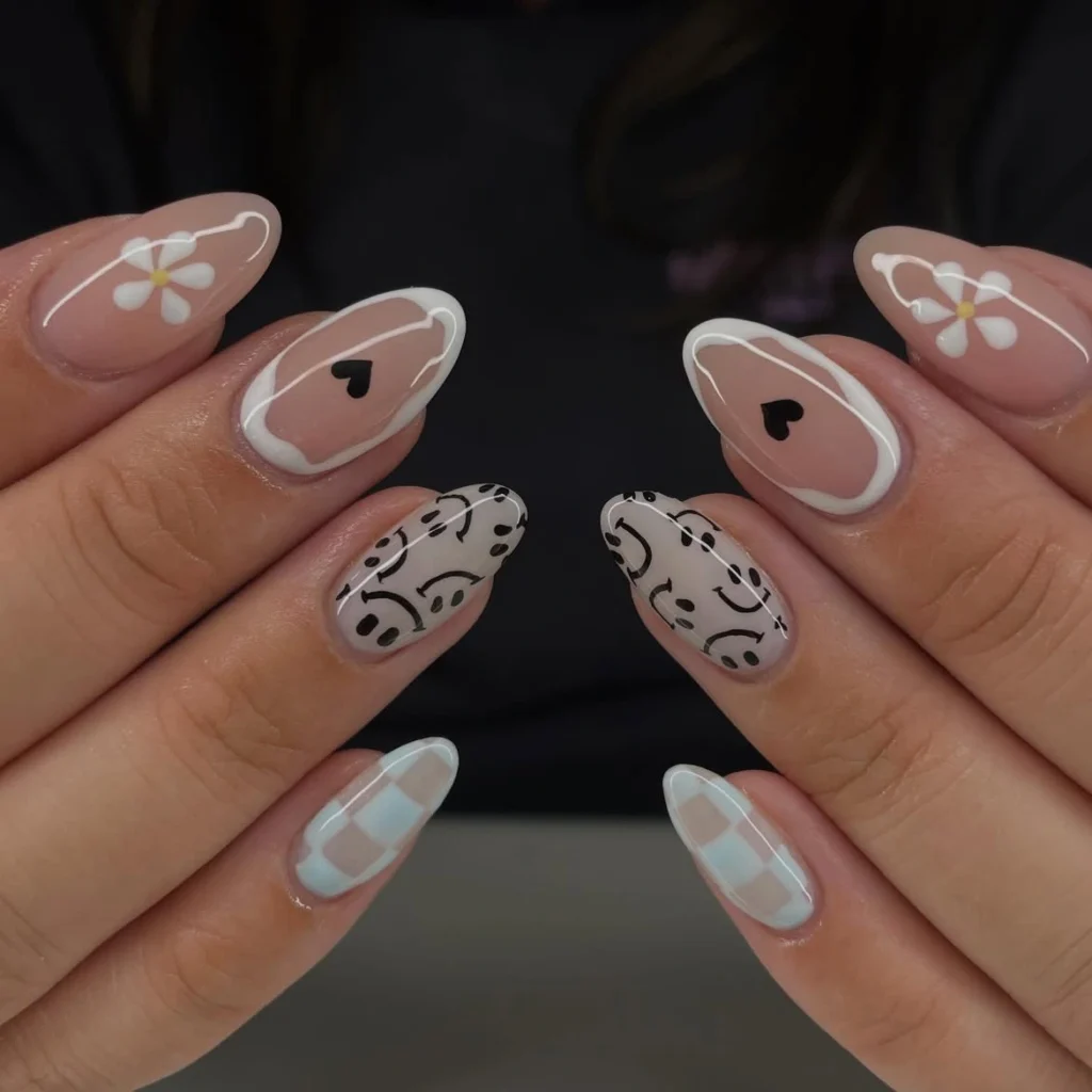 Summer smiley face nails in neutral black and white with daisy, heart, checkerboard and mixed smiley faces on long almond nails