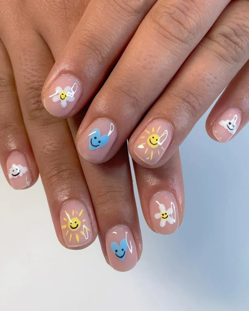 Summer smiley face nails on short nude nails with smiling sun, blue heart, white cloud and daisy accents